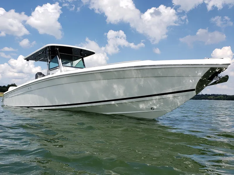 Slide: The Image of 2025 Marlago 37 SS boat on water under a blue sky with clouds. - 0