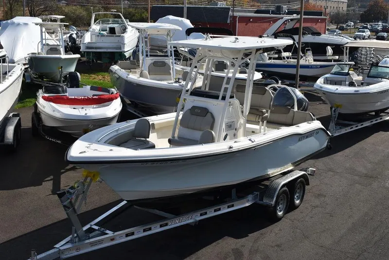 Slide: The Image of 2022 Key West 219fs boat on trailer, surrounded by other boats in a marina. - 1