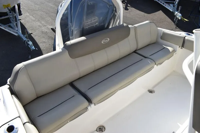 Slide: The Image of 2022 Key West 219fs boat with beige cushioned seating, outdoor setting. - 27