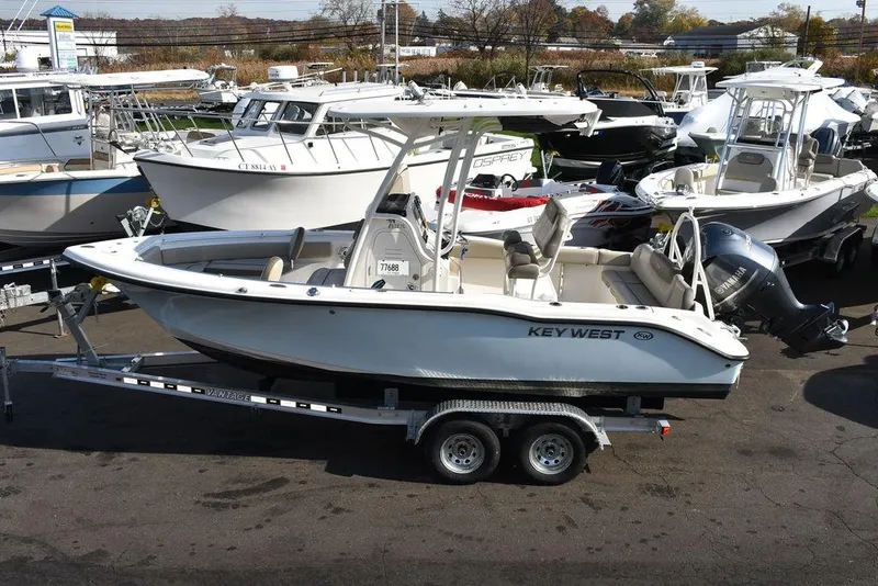 Slide: The Image of 2022 Key West 219fs boat on trailer, surrounded by other boats. - 4