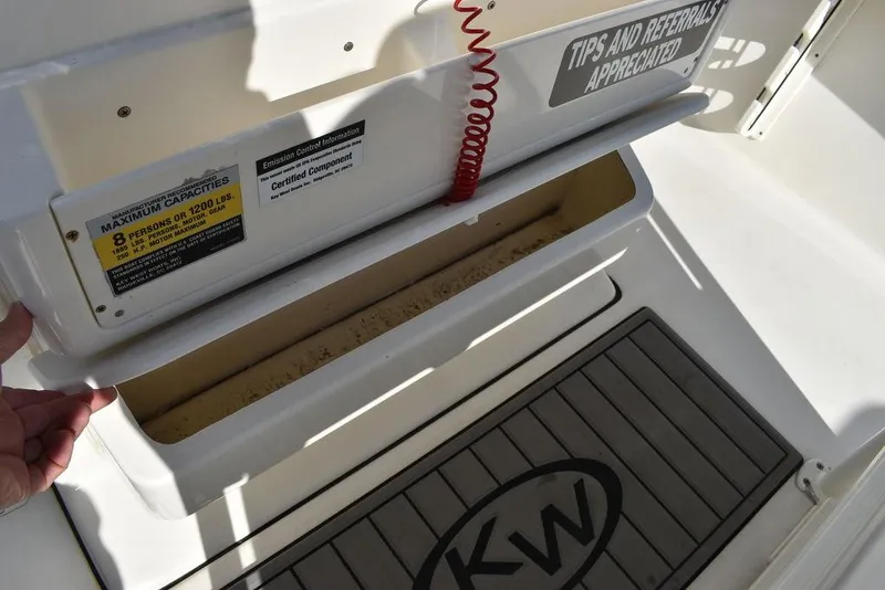 Slide: The Image of Key West 219fs boat interior, 2022 model, showing storage compartment and KW logo mat. - 45
