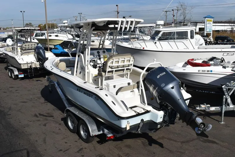 Slide: The Image of 2022 Key West 219fs boat on trailer in marina, surrounded by other boats. - 5