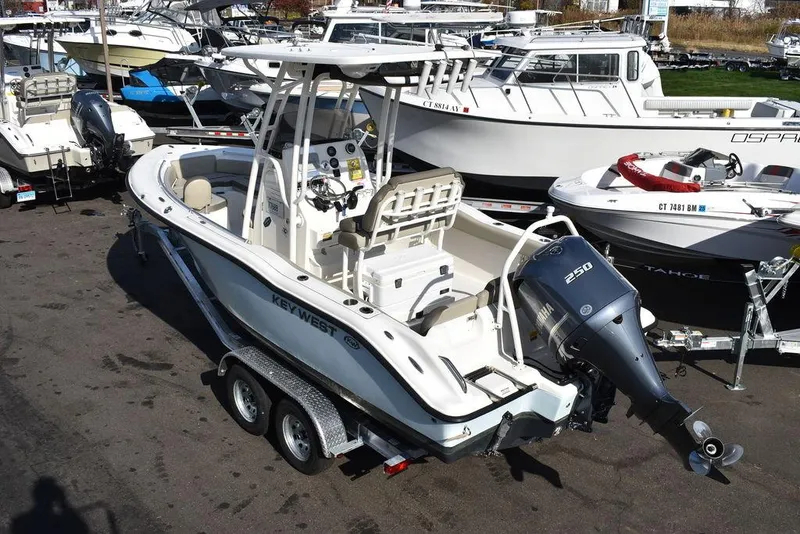 Slide: The Image of 2022 Key West 219fs boat on trailer, parked in marina with other boats. - 6
