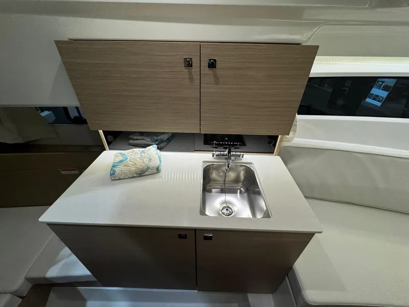 Slide: The Image of Interior of 2025 Jeanneau Leader 9.0 WA Series 2, featuring a compact kitchenette. - 13