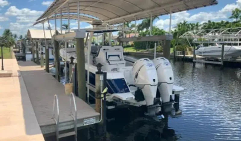 Slide: The Image of 2015 Intrepid 327 Center Console boat docked under canopy. - 11