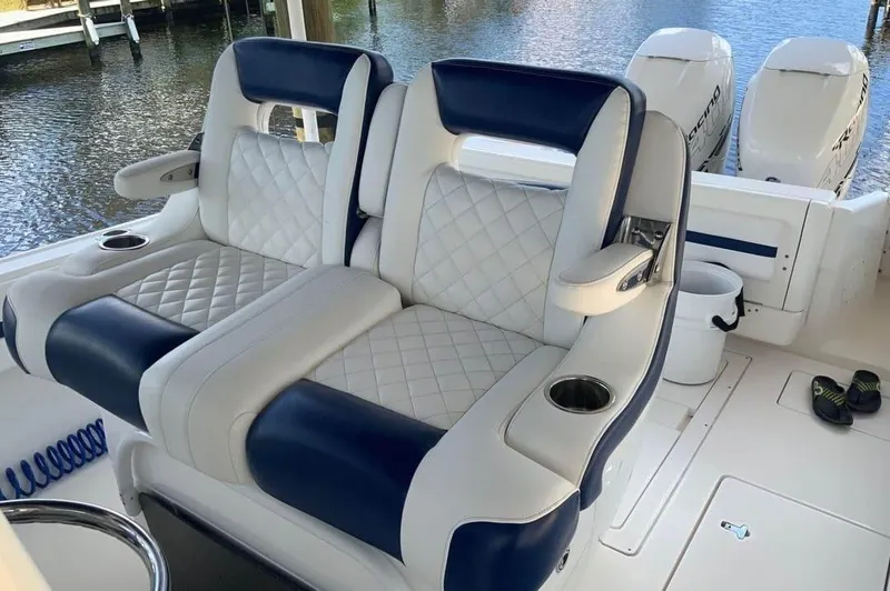 Slide: The Image of 2015 Intrepid 327 Center Console boat seats with quilted upholstery and cup holders. - 13