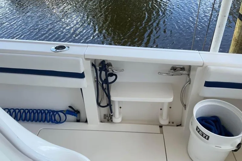 Slide: The Image of 2015 Intrepid 327 Center Console boat interior with fishing gear and Yeti bucket. - 18
