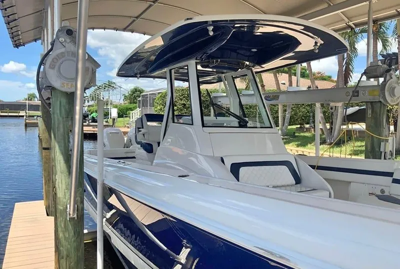 Slide: The Image of 2015 Intrepid 327 Center Console boat docked under canopy. - 22