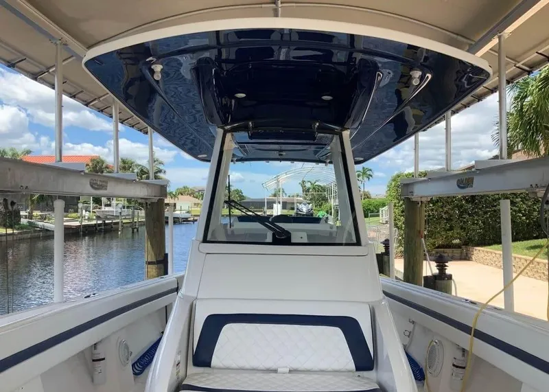 Slide: The Image of 2015 Intrepid 327 Center Console boat docked by a scenic canal. - 23