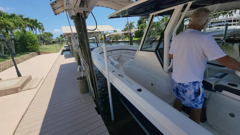 Slide: The Image of Man on 2015 Intrepid 327 Center Console boat docked by a sunny marina. - 30