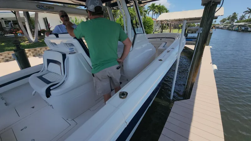 Slide: The Image of 2015 Intrepid 327 Center Console boat docked, featuring spacious seating and sleek design. - 34