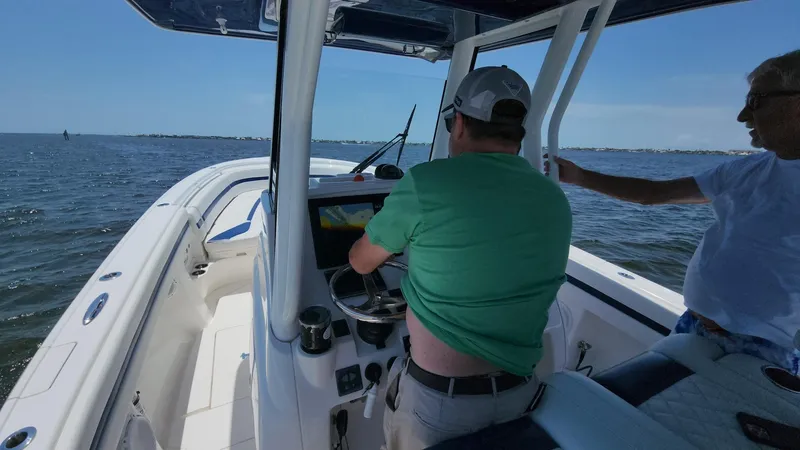 Slide: The Image of Two people navigating a 2015 Intrepid 327 Center Console boat on open water. - 36