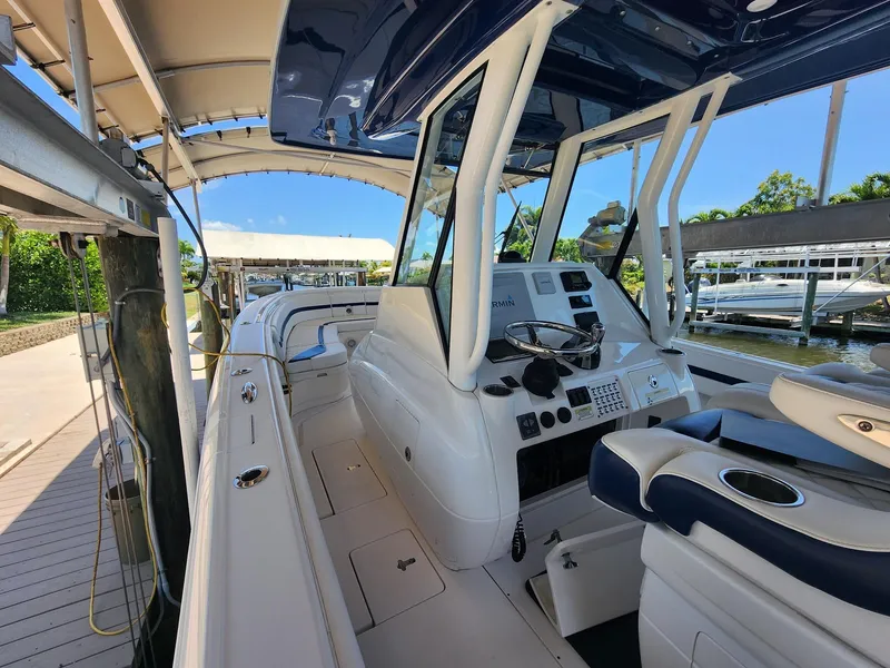 Slide: The Image of 2015 Intrepid 327 Center Console boat docked, featuring sleek design and modern controls. - 38