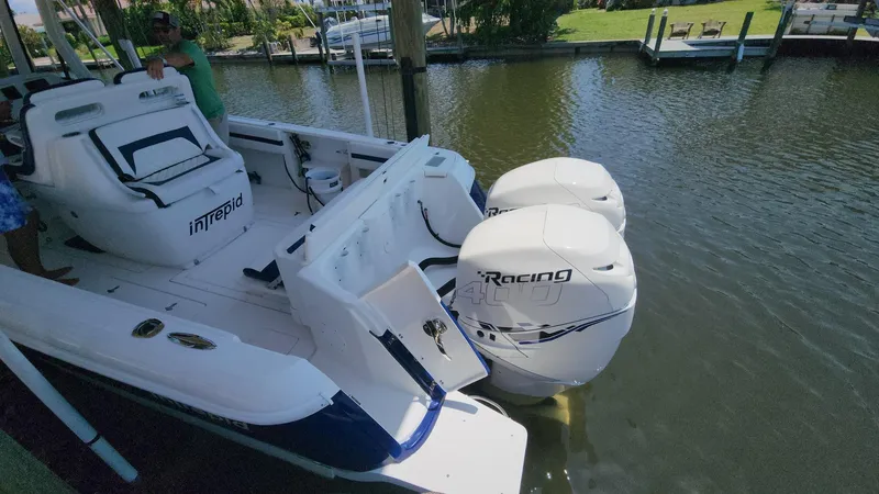 Slide: The Image of 2015 Intrepid 327 Center Console boat with twin outboard engines docked in a marina. - 39