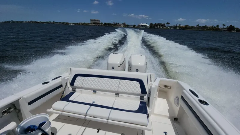 Slide: The Image of 2015 Intrepid 327 Center Console boat cruising on open water, leaving a wake behind. - 45