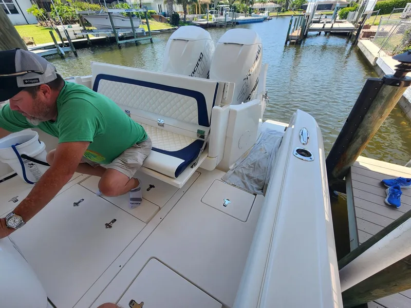 Slide: The Image of 2015 Intrepid 327 Center Console boat docked, man in green shirt adjusting equipment. - 46