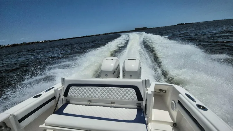 Slide: The Image of 2015 Intrepid 327 Center Console boat cruising on open water, leaving a wake behind. - 49