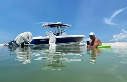 Slide: The Image of 2015 Intrepid 327 Center Console boat on water with person relaxing nearby. - 5