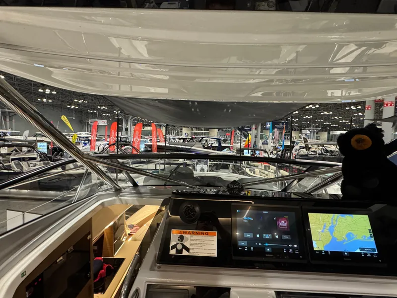 Slide: The Image of 2025 Jeanneau Leader 10.5 WA Series 2 cockpit with navigation displays at a boat show. - 16