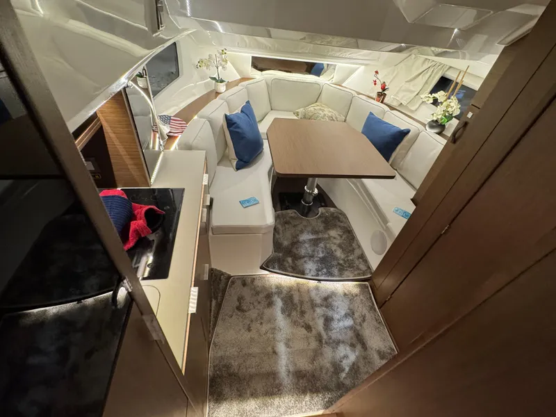 Slide: The Image of 2025 Jeanneau Leader 10.5 WA Series 2 interior with cozy seating and dining area. - 18