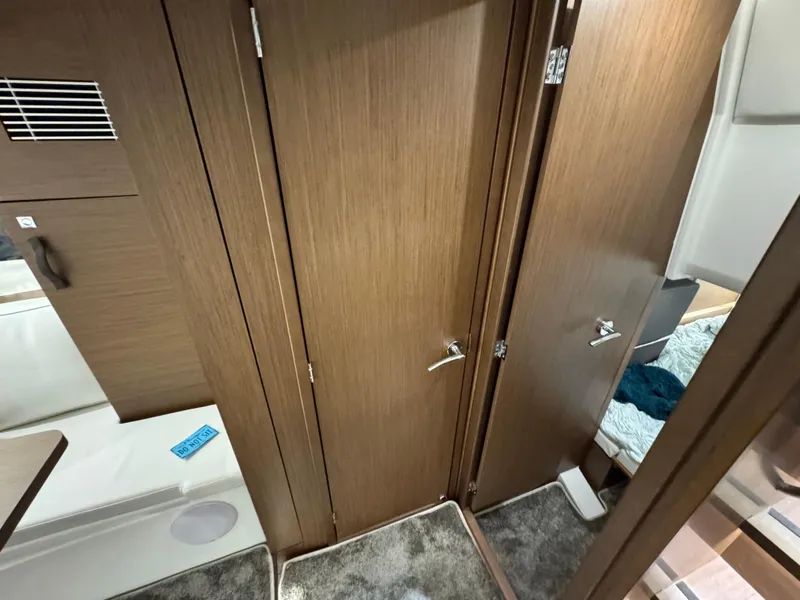 Slide: The Image of Interior of 2025 Jeanneau Leader 10.5 WA Series 2, featuring wooden cabinetry and carpeted flooring. - 21