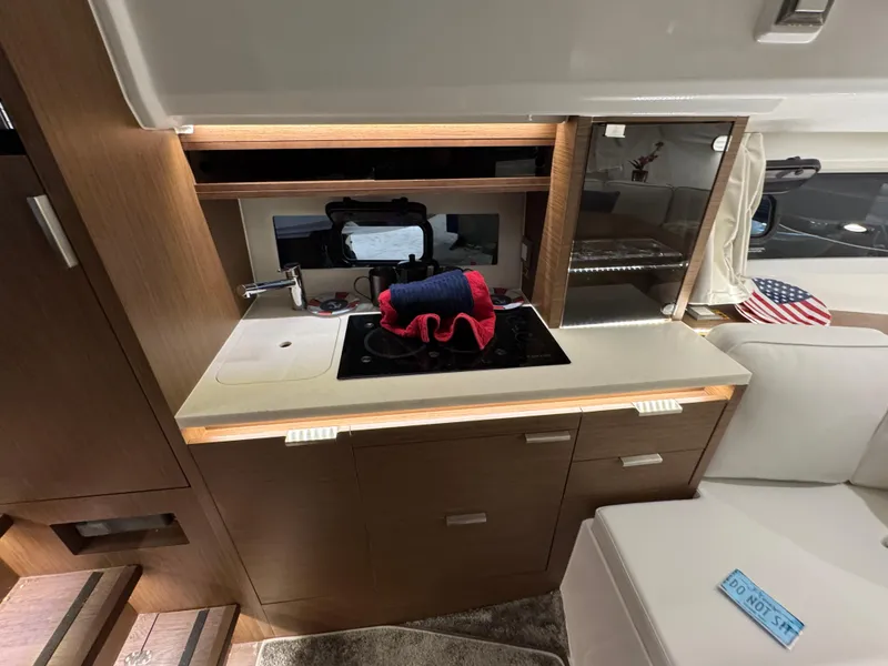 Slide: The Image of Interior of 2025 Jeanneau Leader 10.5 WA Series 2, featuring a modern kitchenette with stove and sink. - 19