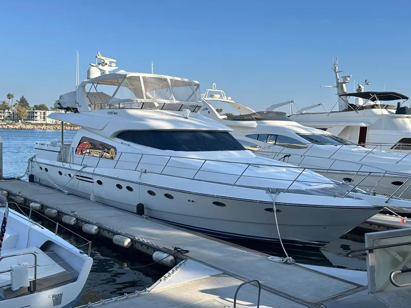 The Image of Luxury 2001 Johnson 70 yacht docked at marina under clear blue sky. - 0