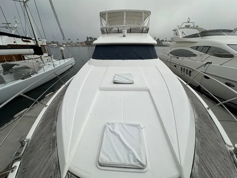 Slide: The Image of 2001 Johnson 70 yacht docked at marina, showcasing sleek design and spacious deck. - 1