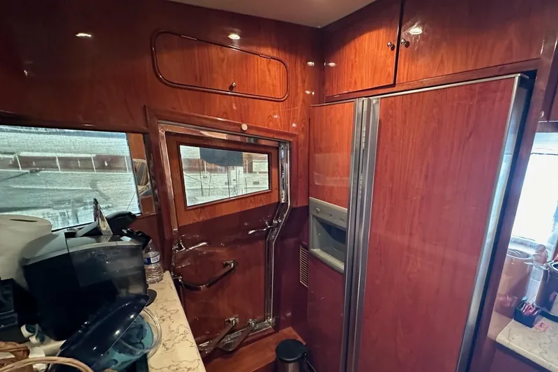 Slide: The Image of Luxurious 2001 Johnson 70 yacht interior with wood paneling and modern kitchen amenities. - 11