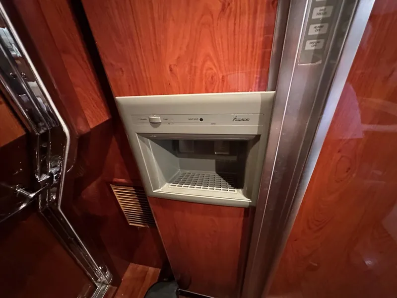 Slide: The Image of Built-in ice maker on a 2001 Johnson 70 yacht with wood paneling. - 12