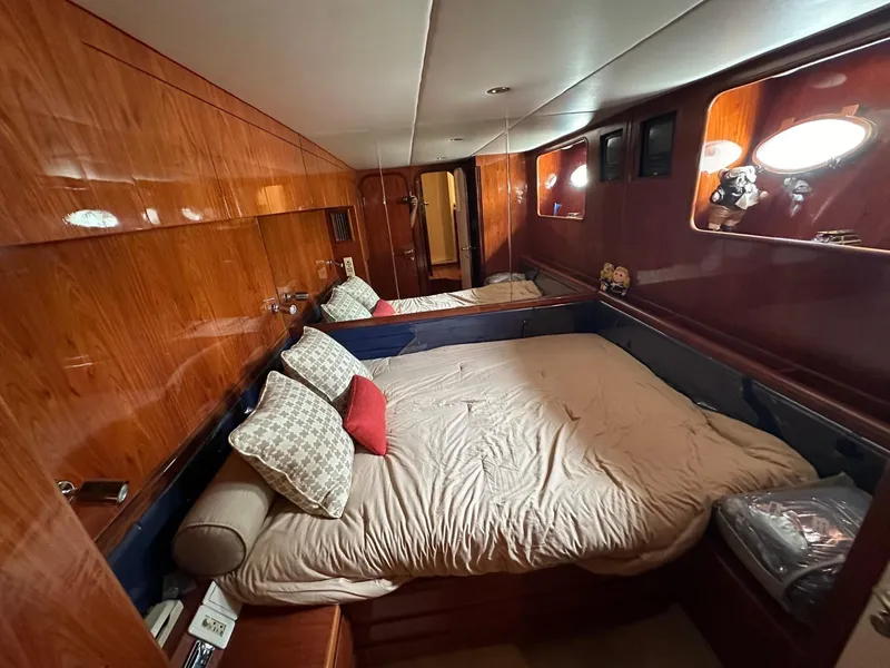 Slide: The Image of Luxurious cabin interior of a 2001 Johnson 70 yacht with wood paneling and cozy bedding. - 27