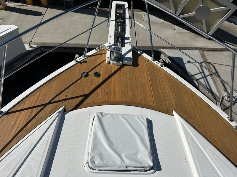 Slide: The Image of Johnson 70 boat deck, 2001 model, featuring teak wood finish and metal railings. - 3