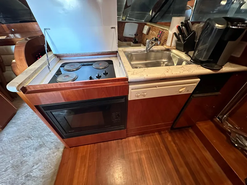 Slide: The Image of Compact kitchen in a 2001 Johnson 70 yacht with stove, sink, and microwave. - 30