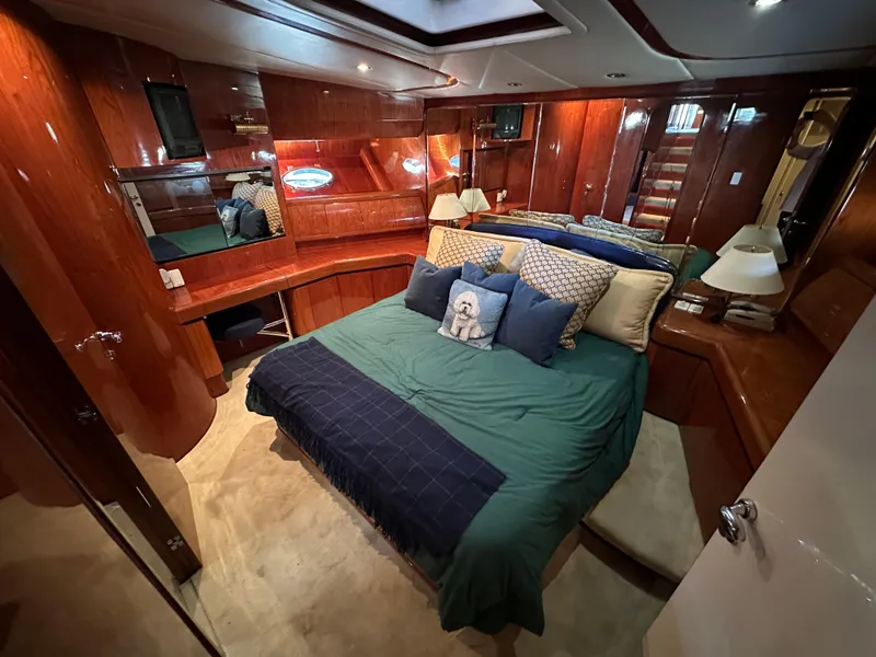 Slide: The Image of Luxurious 2001 Johnson 70 yacht bedroom with elegant wood paneling and cozy bedding. - 34