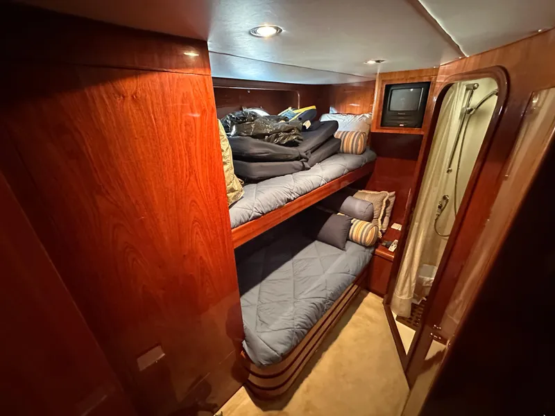Slide: The Image of Cozy cabin with wooden interior, bunk beds, and a small TV on a 2001 Johnson 70 yacht. - 40