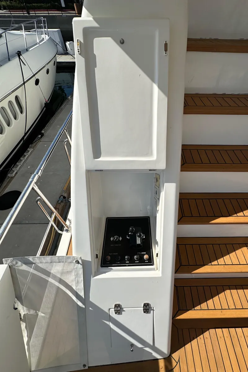 Slide: The Image of Control panel on 2001 Johnson 70 yacht, near wooden steps and docked boat. - 43
