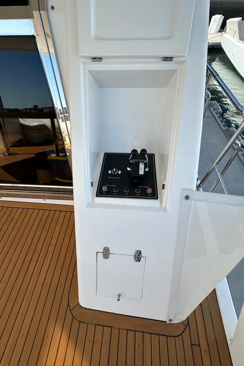 Slide: The Image of Control panel on a 2001 Johnson 70 yacht, featuring sleek design and wooden deck. - 44