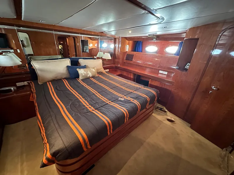 Slide: The Image of Luxurious cabin interior of 2001 Johnson 70 yacht with striped bedding and wood paneling. - 9