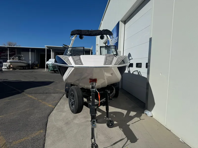 Slide: The Image of 2022 Moomba Mondo boat on trailer outside a garage. - 3