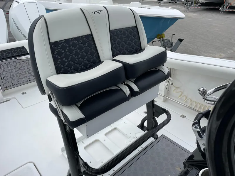 Slide: The Image of 2021 Tidewater 272 CC Adventure boat seating with black and white cushioned design. - 10
