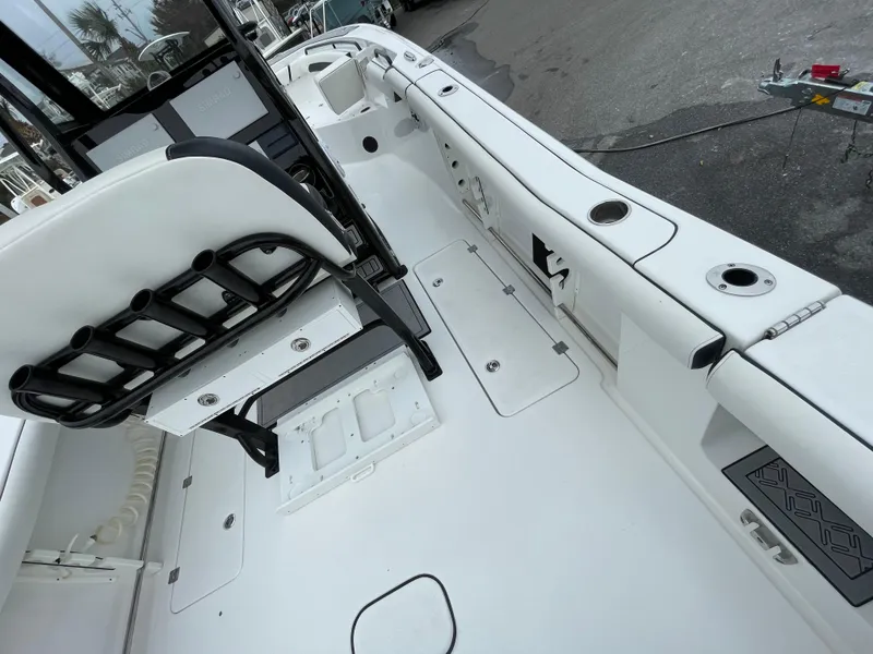 Slide: The Image of 2021 Tidewater 272 CC Adventure boat interior with rod holders and seating. - 12