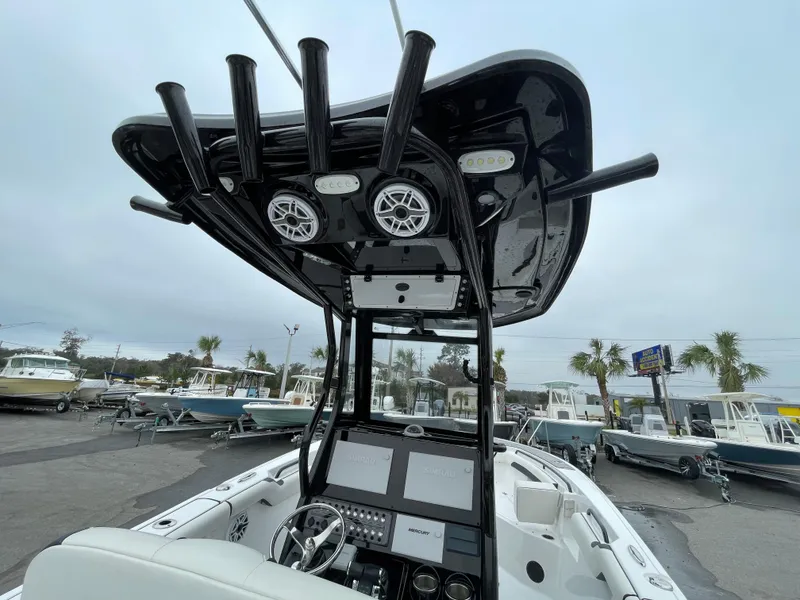 Slide: The Image of 2021 Tidewater 272 CC Adventure boat with advanced dashboard and speakers, docked in a marina. - 14