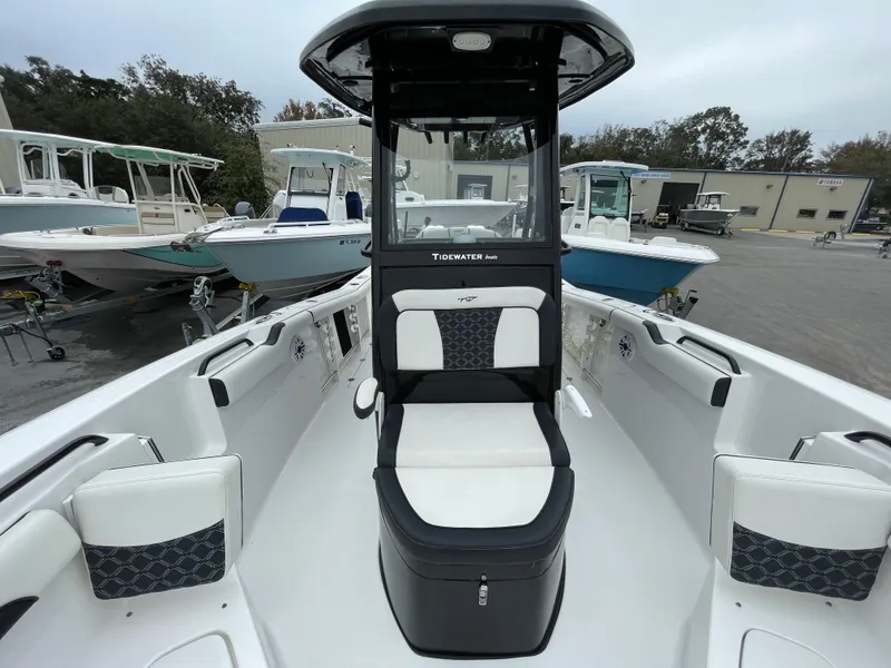 Slide: The Image of 2021 Tidewater 272 CC Adventure boat interior with seating and console, docked at a marina. - 5