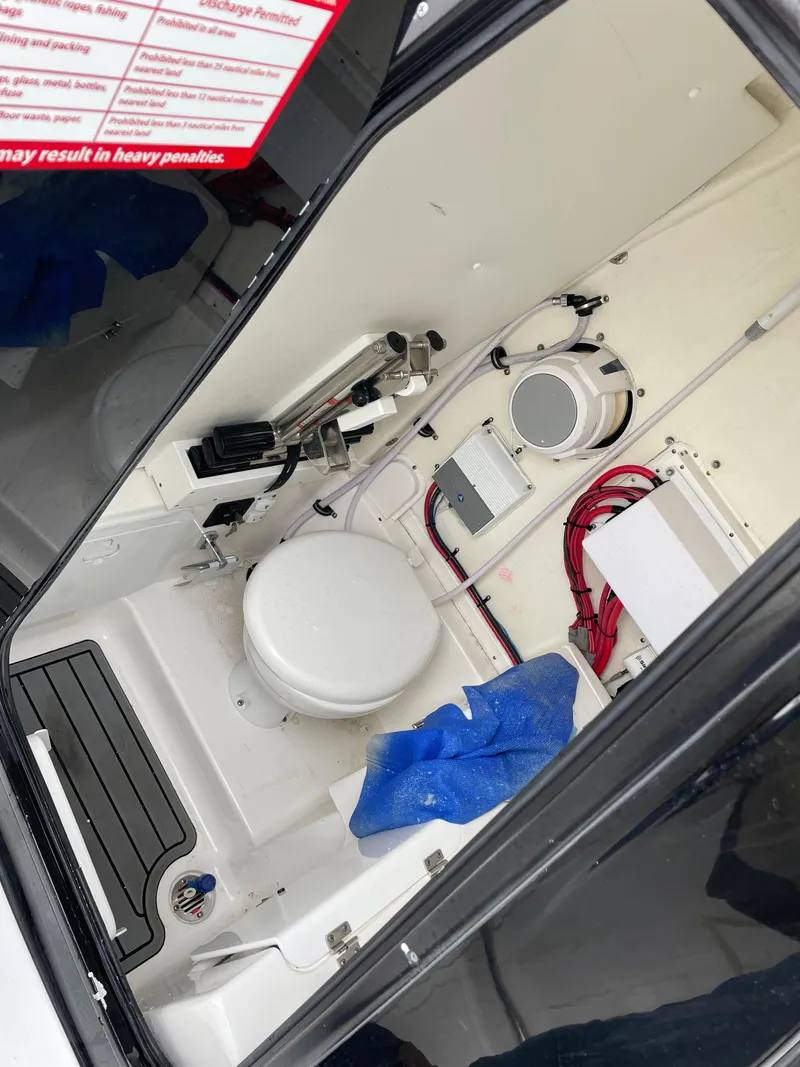 Slide: The Image of 2021 Tidewater 272 CC Adventure boat interior with toilet and storage area. - 7