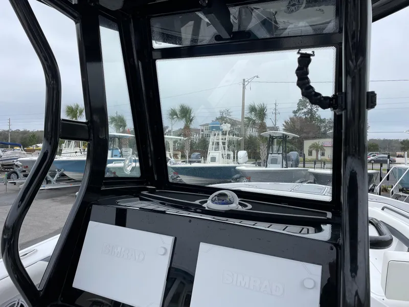 Slide: The Image of 2021 Tidewater 272 CC Adventure boat dashboard with Simrad displays and compass. - 9