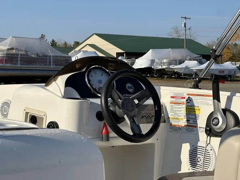 Slide: The Image of 2019 Bayliner E16 boat dashboard with steering wheel and controls. - 6