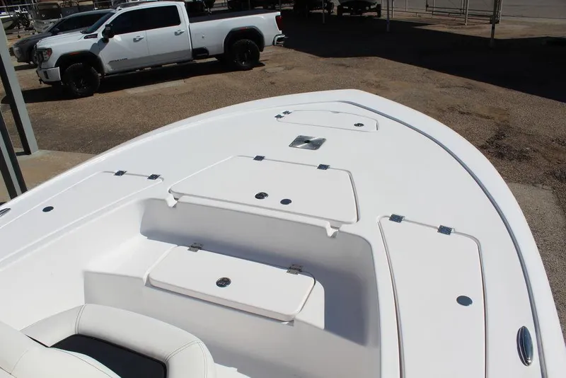 Slide: The Image of 2025 Tidewater 2110 Bay Max boat deck with storage compartments, parked truck in background. - 19
