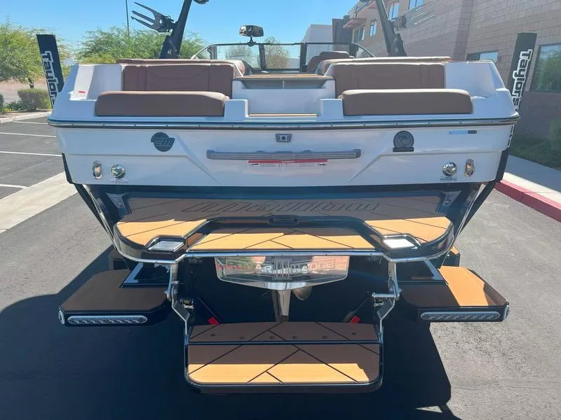 Slide: The Image of 2025 Malibu 23 LSV boat rear view with teak deck and seating. - 10