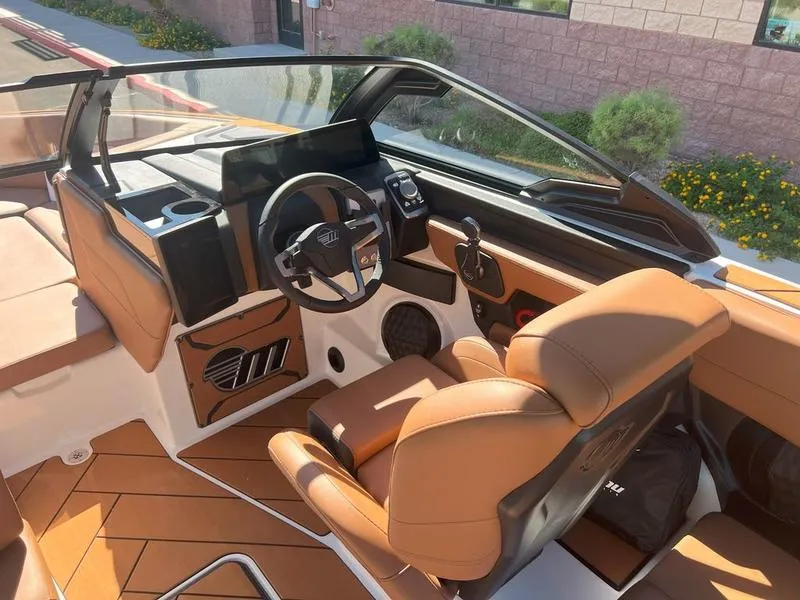Slide: The Image of 2025 Malibu 23 LSV boat interior with tan leather seats and modern dashboard. - 17