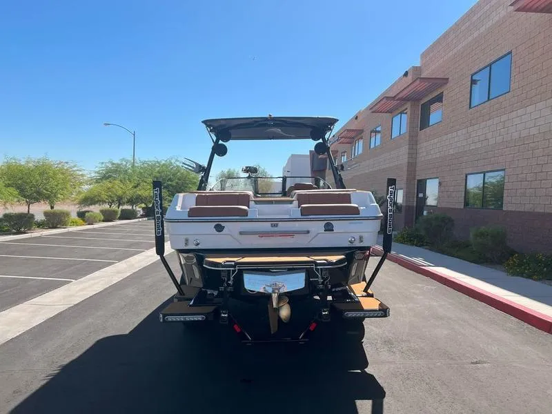 Slide: The Image of 2025 Malibu 23 LSV boat parked outdoors, rear view. - 2